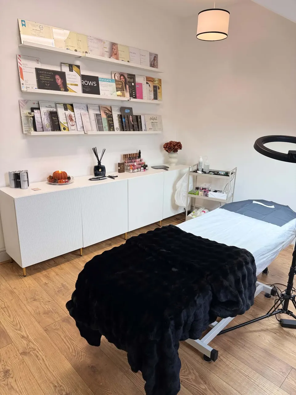 The treatment room at Defined Studio, with a treatment bed, ring light and white sideboard